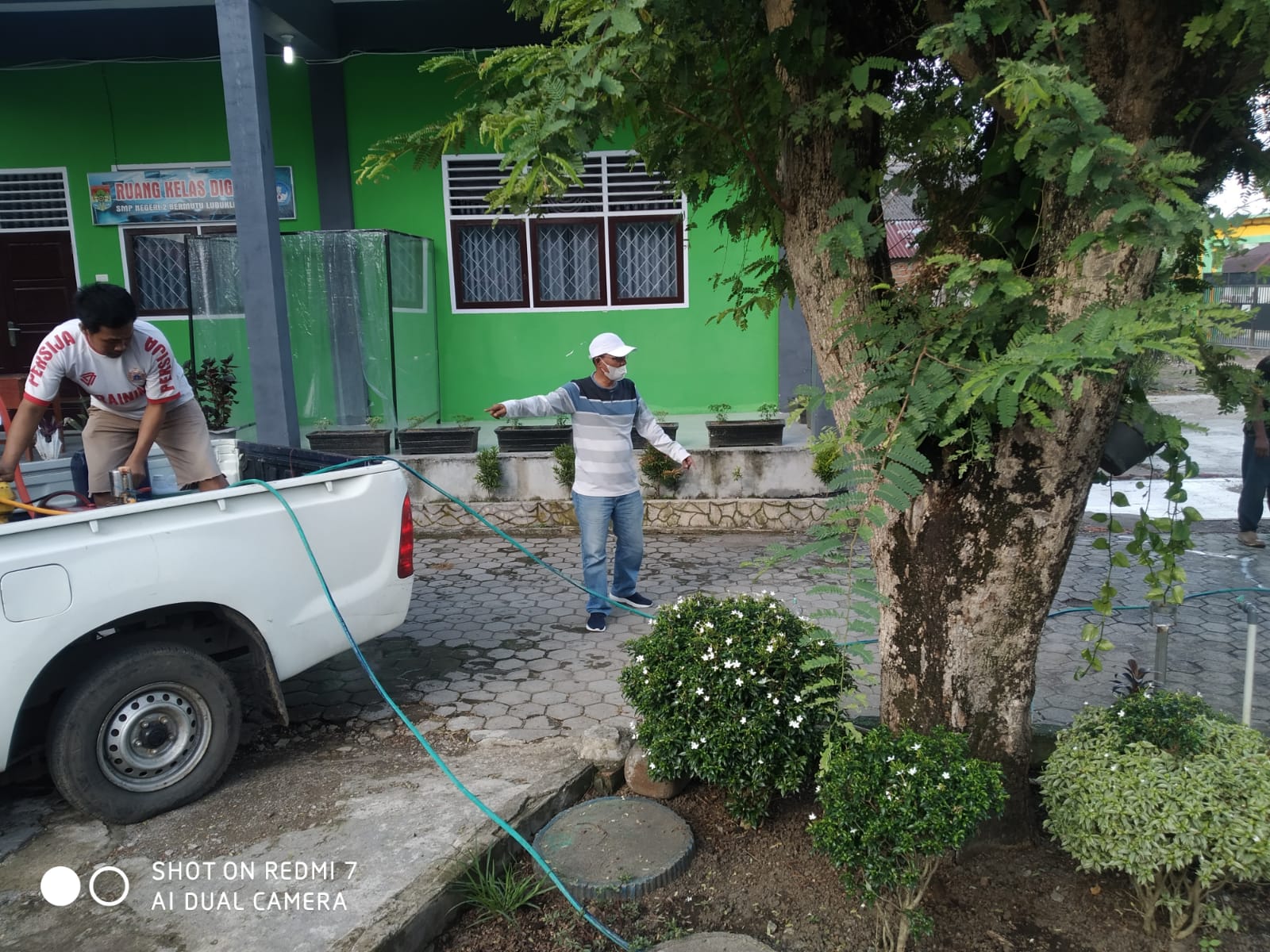 Parman Kepala SMPN 2 Lubuklinggau memimpin penyemprotan disinfektan di lingkungan sekolahnya. 